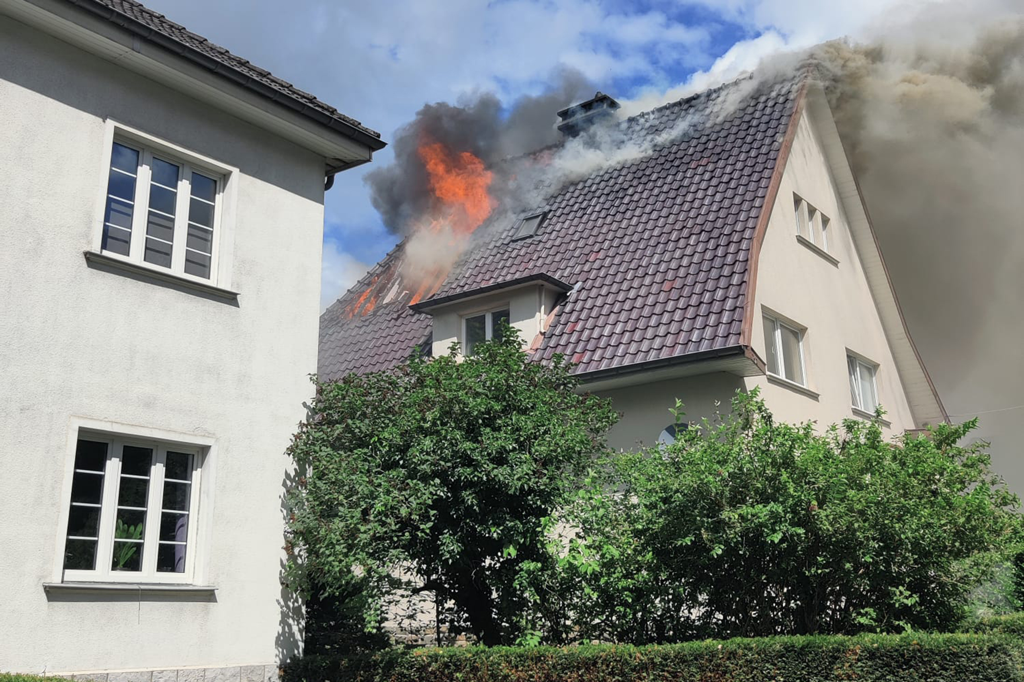 Brand im Lascheterweg in Eupen - Flammen schlagen aus einem Dachgeschossfenster