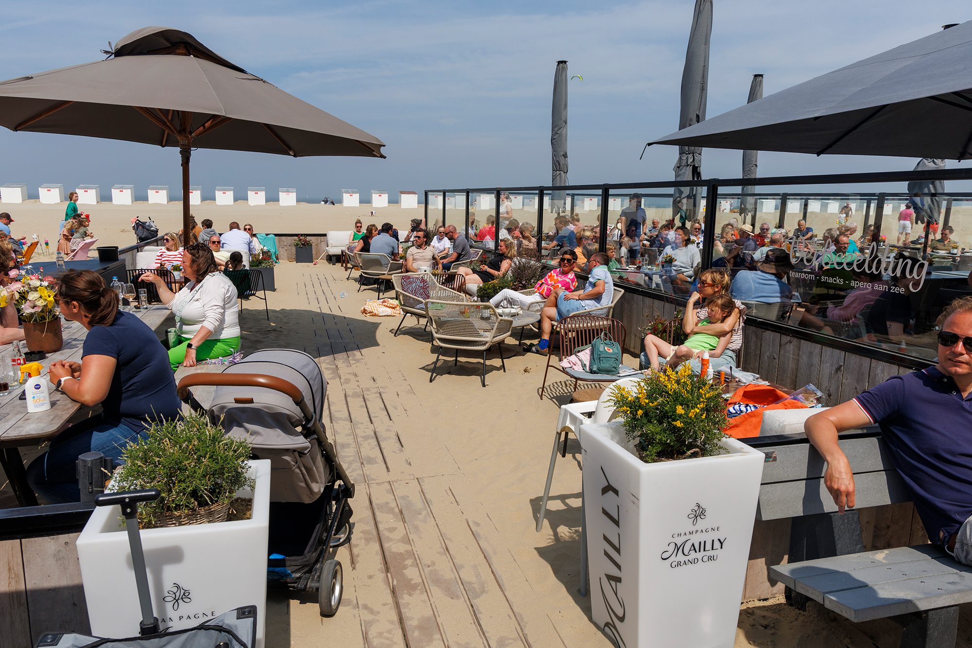 Touristen genießen das gute Wetter auf einer Terrasse in Oostduinkerke