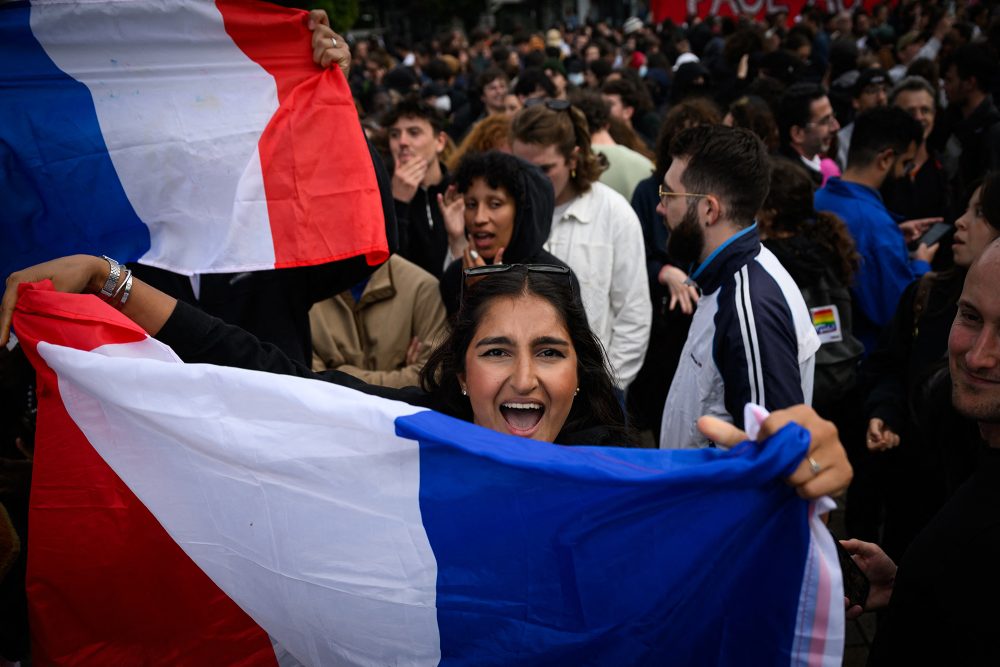 Eine Frau hält eine französische Nationalflagge während einer Demonstration in Nantes nach der Bekanntgabe der voraussichtlichen Ergebnisse der zweiten Runde der französischen Parlamentswahlen