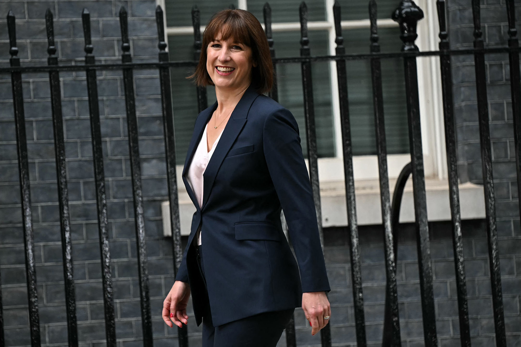 Die neue britische Finanzministerin Rachel Reeves geht die Downing Street in London entlang und lächelt in die Kamera