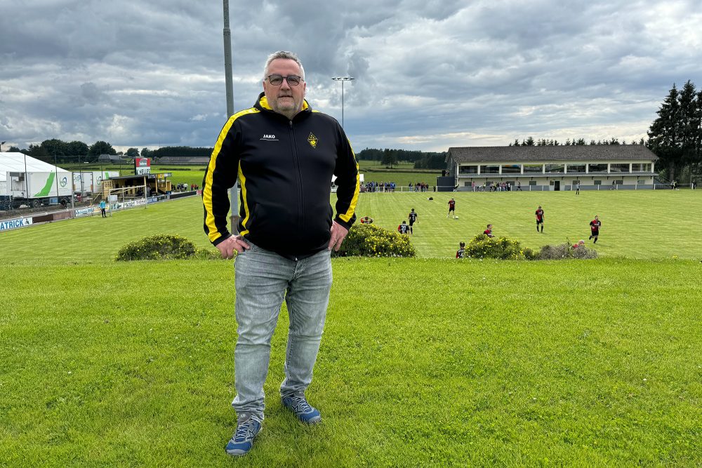 Der Präsident vom KFC Weywertz, Roland Gilles, steht vor dem Fußballplatz und schaut in die Kamera