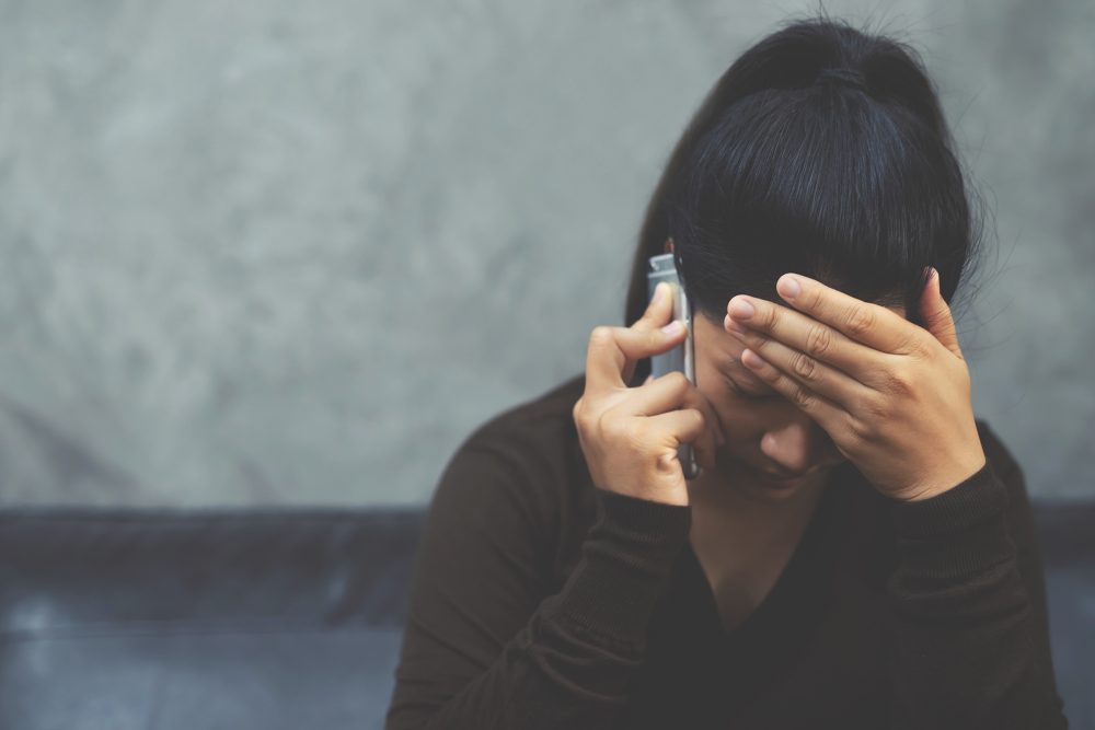 Unglückliche Frau beim Telefonieren