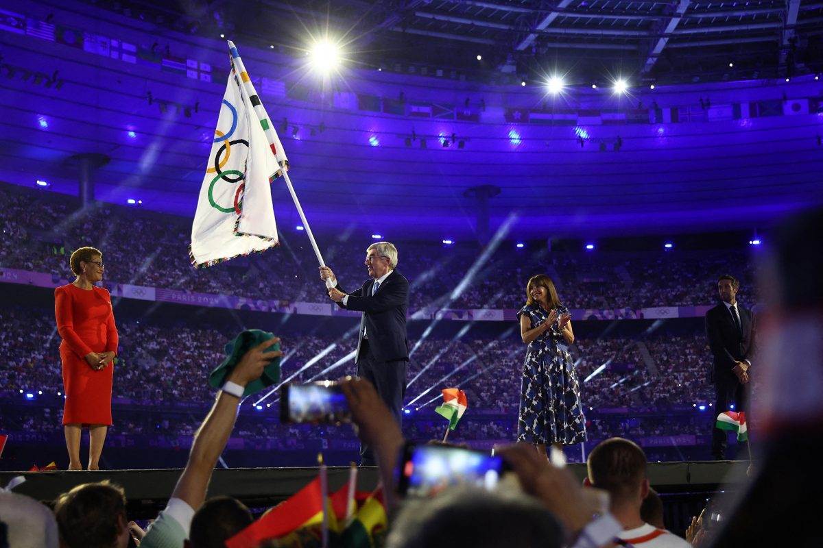 IOC-Präsident Thomas Bach reicht die Flagge an die Bürgermeisterin von Los Angeles, Karen Bass, weiter