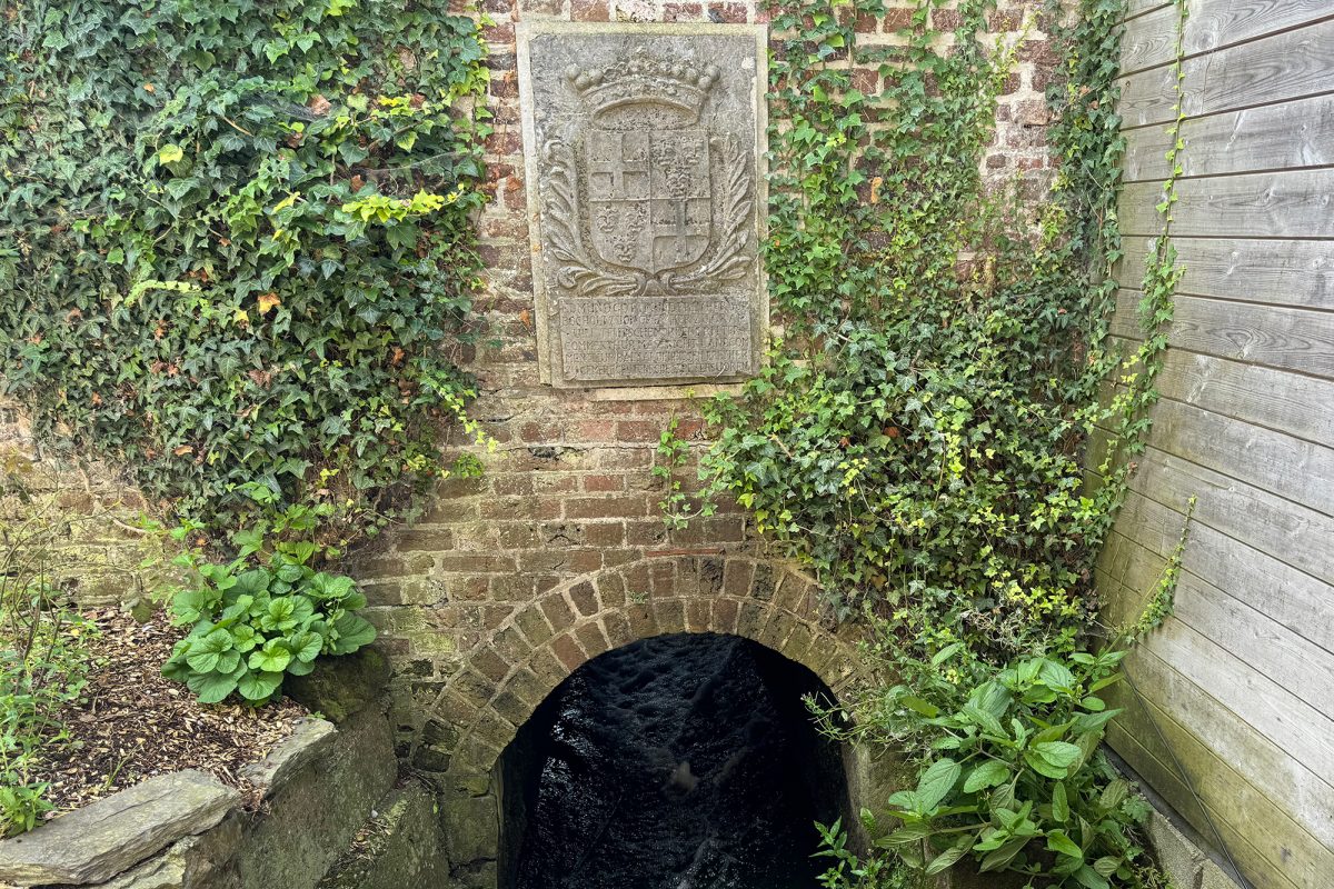 Eine alte Steinmauer mit einer runden Öffnung an der Quelle der Voer