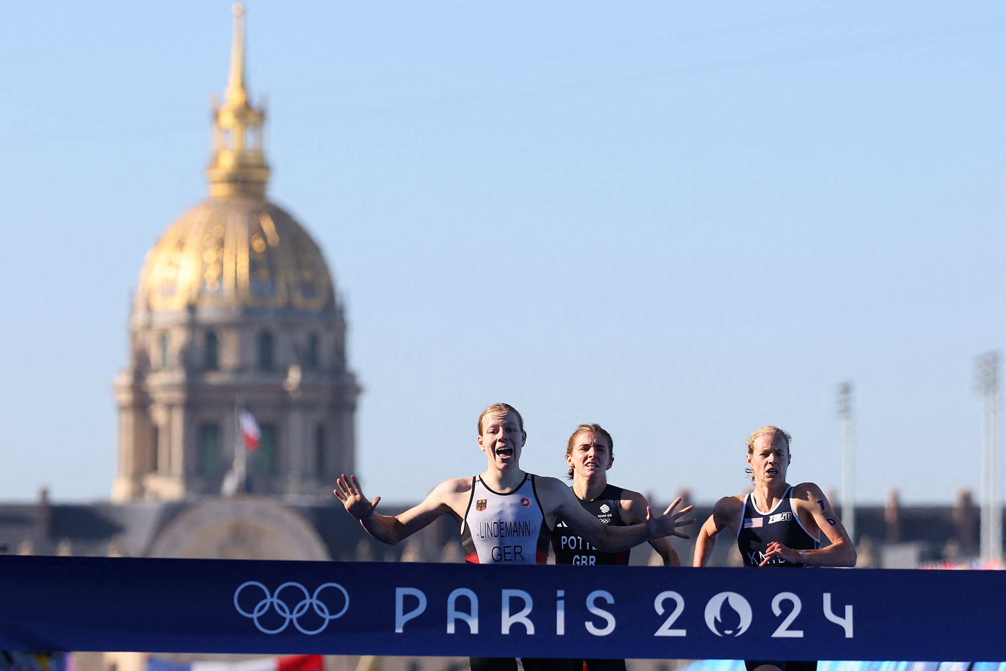 Die Deutsche Laura Lindemann läuft als Erste über die Ziellinie, gefolgt von der Britin Beth Potter und der US-Amerikanerin Taylor Knibb, am Ende des Triathlon-Staffelrennens der Mixed-Staffel bei den Olympischen Spielen in Paris