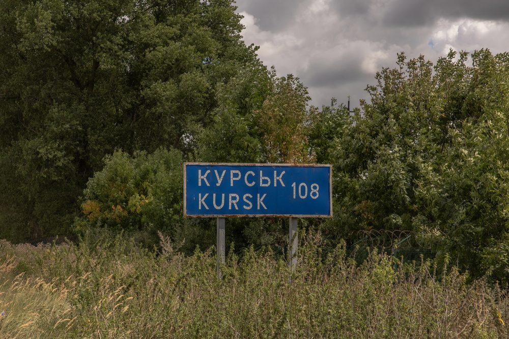 Dieses Foto zeigt ein Straßenschild, das die Entfernung zur russischen Stadt Kursk anzeigt, neben dem zerstörten Grenzübergang zu Russland in der Region Sumy