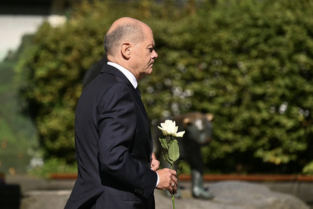 Bundeskanzler Olaf Scholz kommt mit einer weißen Rose in der Hand in der Nähe des Fronhofs in Solingen an