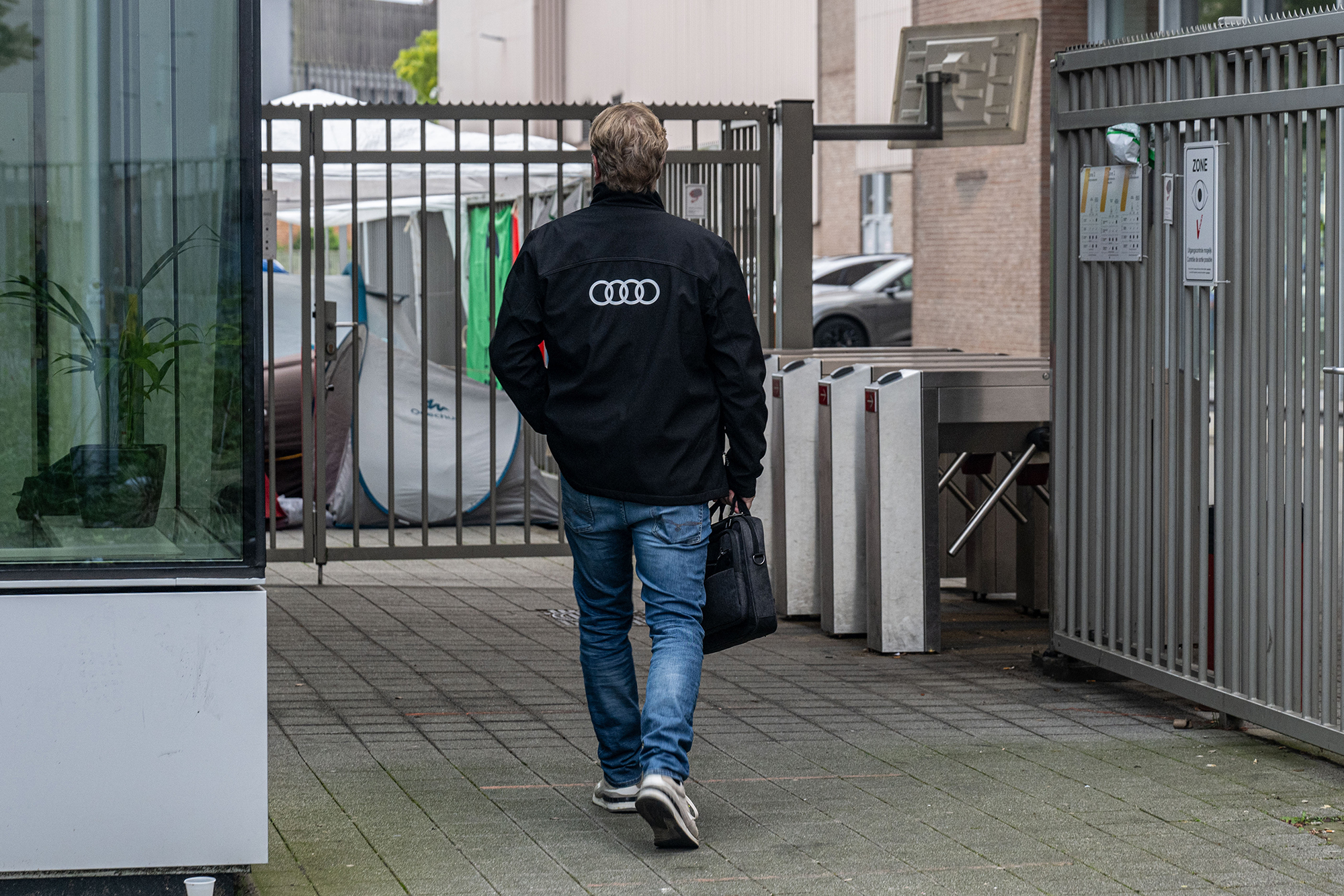 Ein Audi-Mitarbeiter am Eingangsbereich des Audi-Werks in Brüssel, auf dem Weg zur Arbeit