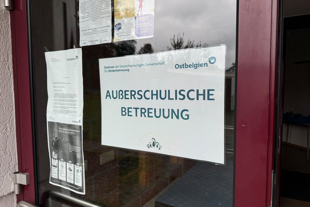 An der Eingangstür des Gebäudes ist ein Schild mit der Aufschrift "Außerschulische Betreuung" angebracht