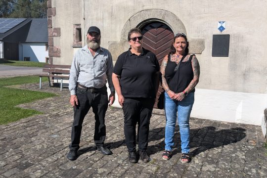 Ludwig Hacken, Marita Eichten und Sonja Hering von der Liste "Büllingen reden wir miteinander" vor der Kapelle in Krewinkel
