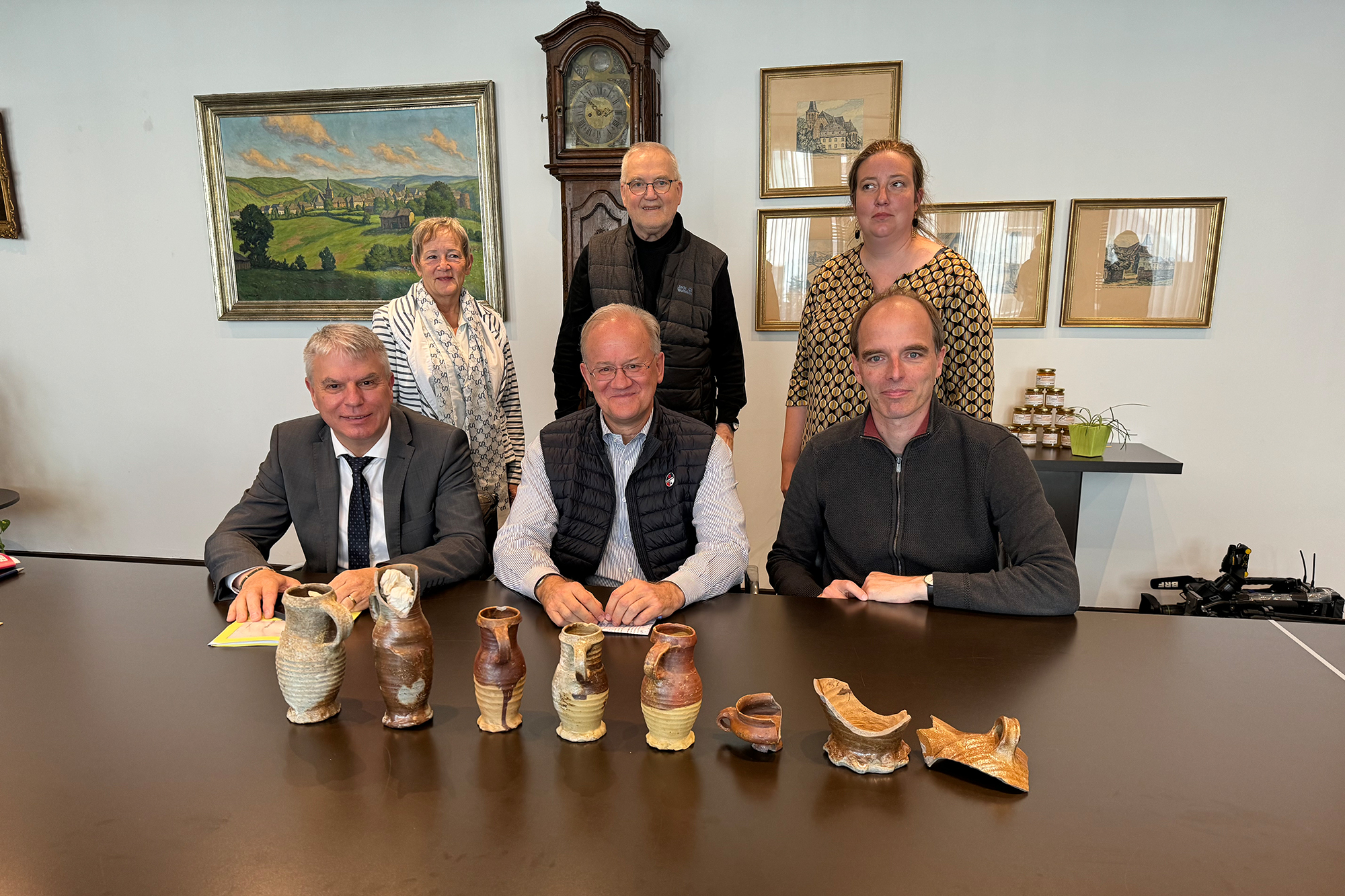 Kulturminister Gregor Freches, Anny Mathey (BI Burg), Bürgermeister Herbert Grommes, Lorenz Paasch (BI Burg), Audrey Olbertz (Archäologischer Dienst der DG) sowie Schöffe Roland Gilson (v.l.n.r.) freuen sich über die Krugfunde im Burggraben