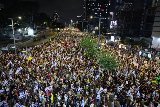 Demonstranten hissen Fahnen und Plakate bei einer Demonstration in Tel Aviv