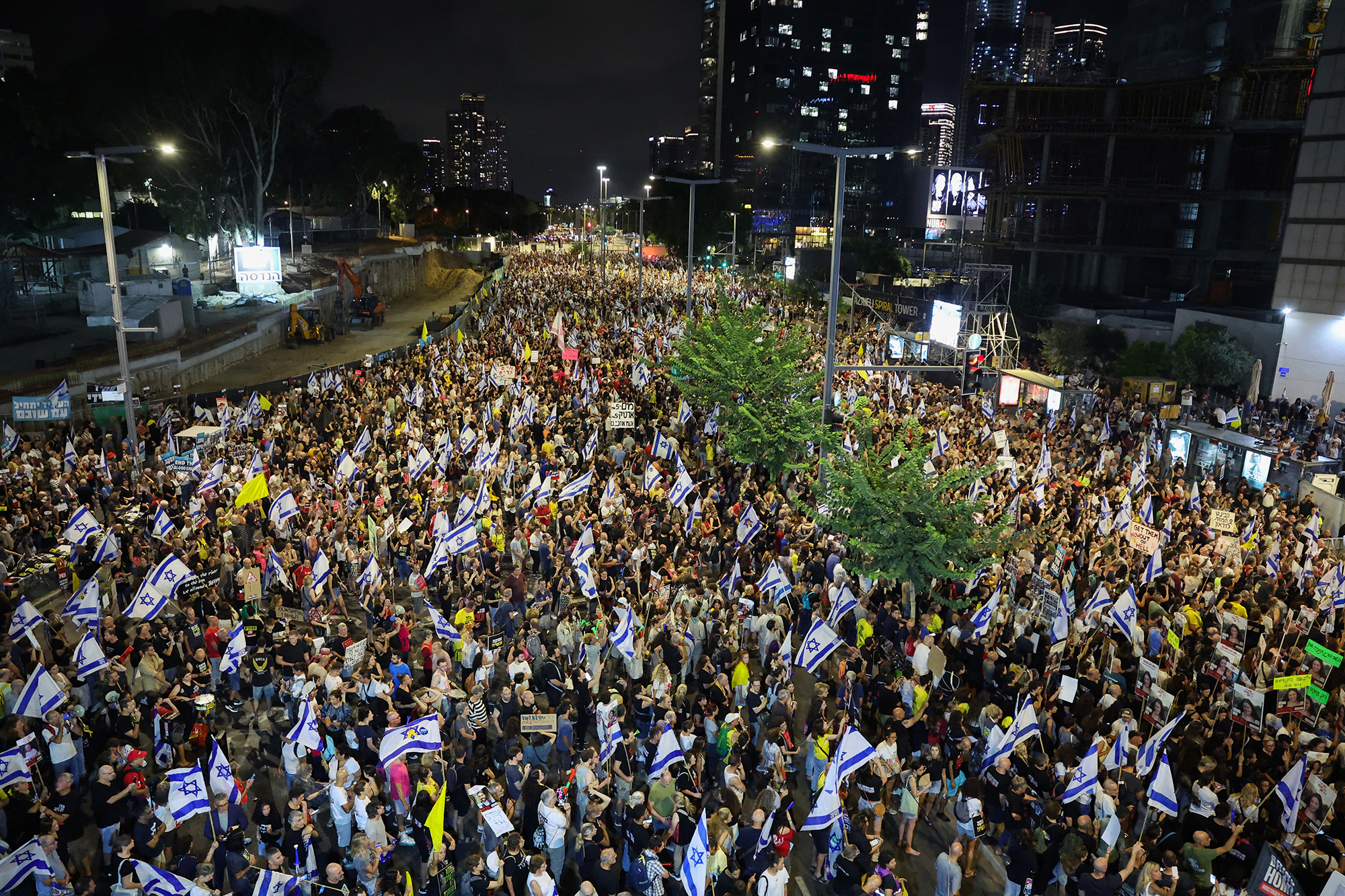 Demonstranten hissen Fahnen und Plakate bei einer Demonstration in Tel Aviv