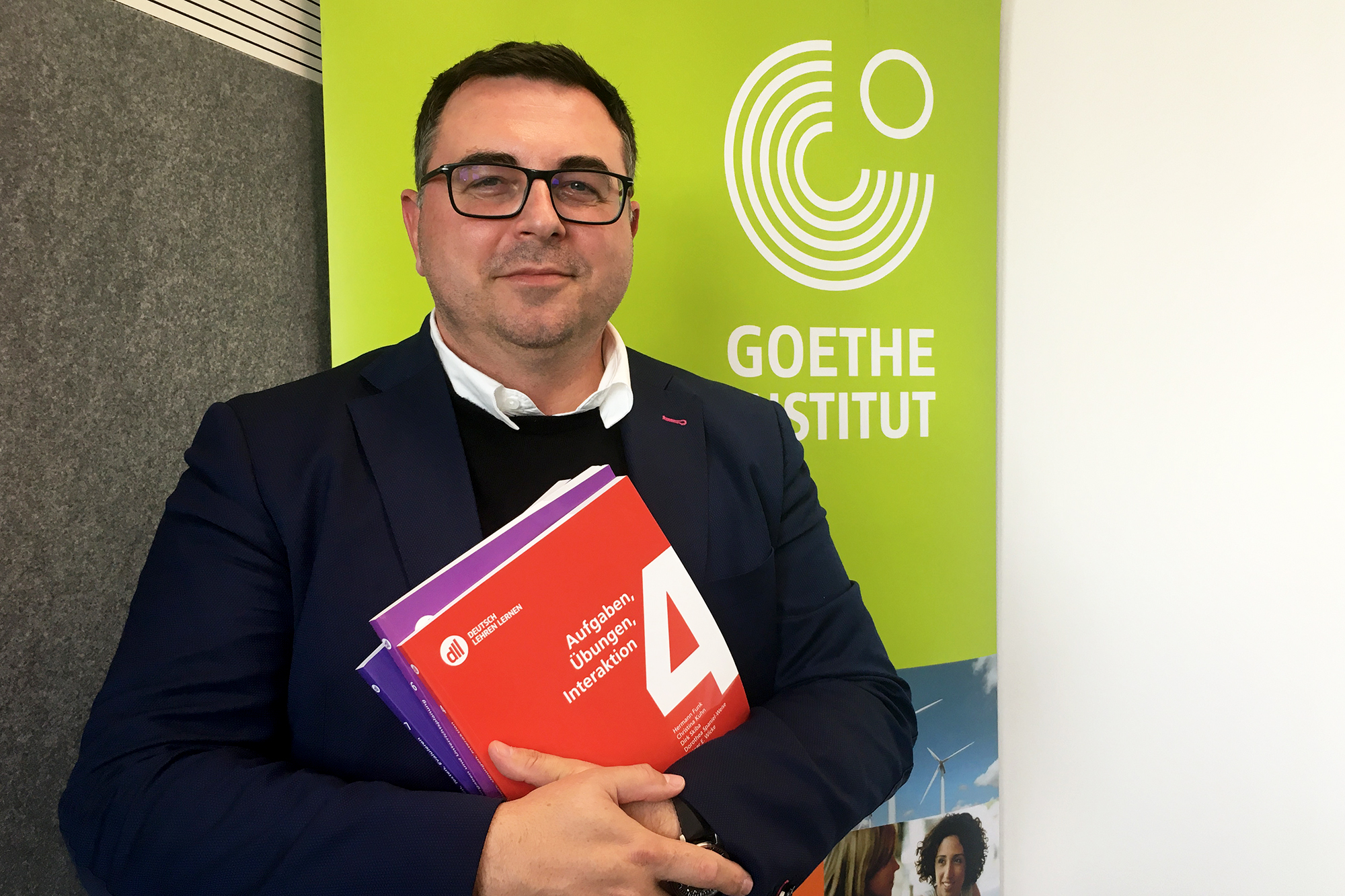 Rafael Deschka, stellvertretender Leiter des Goethe-Instituts Brüssel, mit einigen der Modul-Büchern DLL, die für die neue praxisorientierte Ausbildung von Deutschlehramtsstudenten in Belgien vom Goethe-Institut erarbeitet wurden