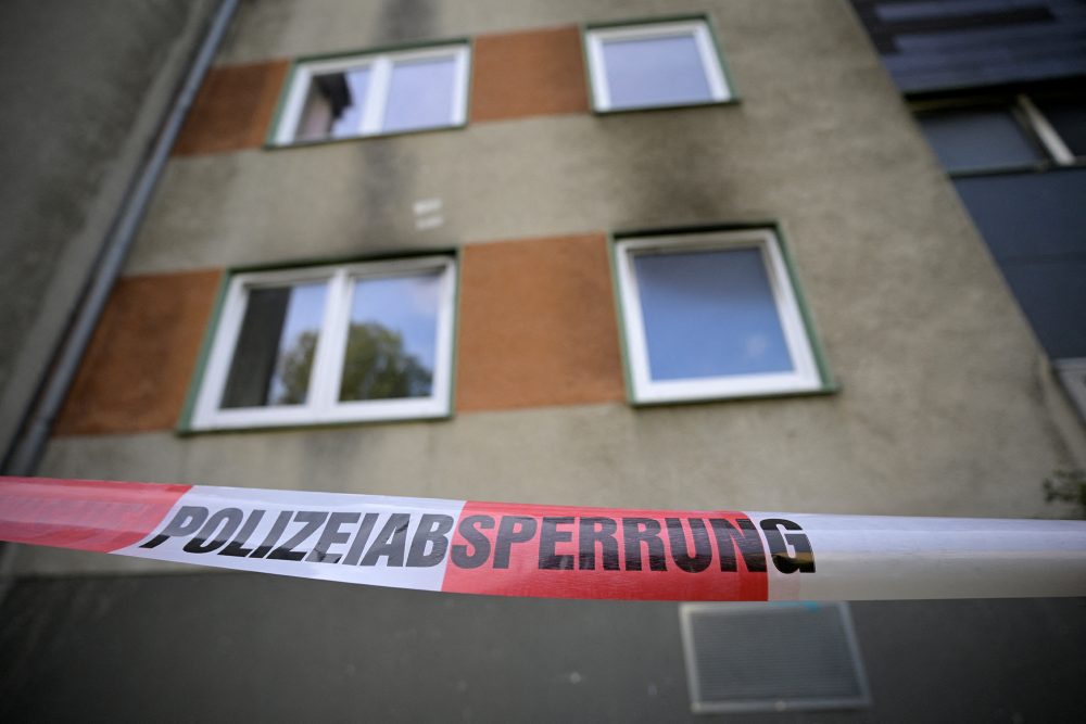 Polizei-Absperrband vor einem Haus, dessen Fassade deutliche Rußspuren aufweist