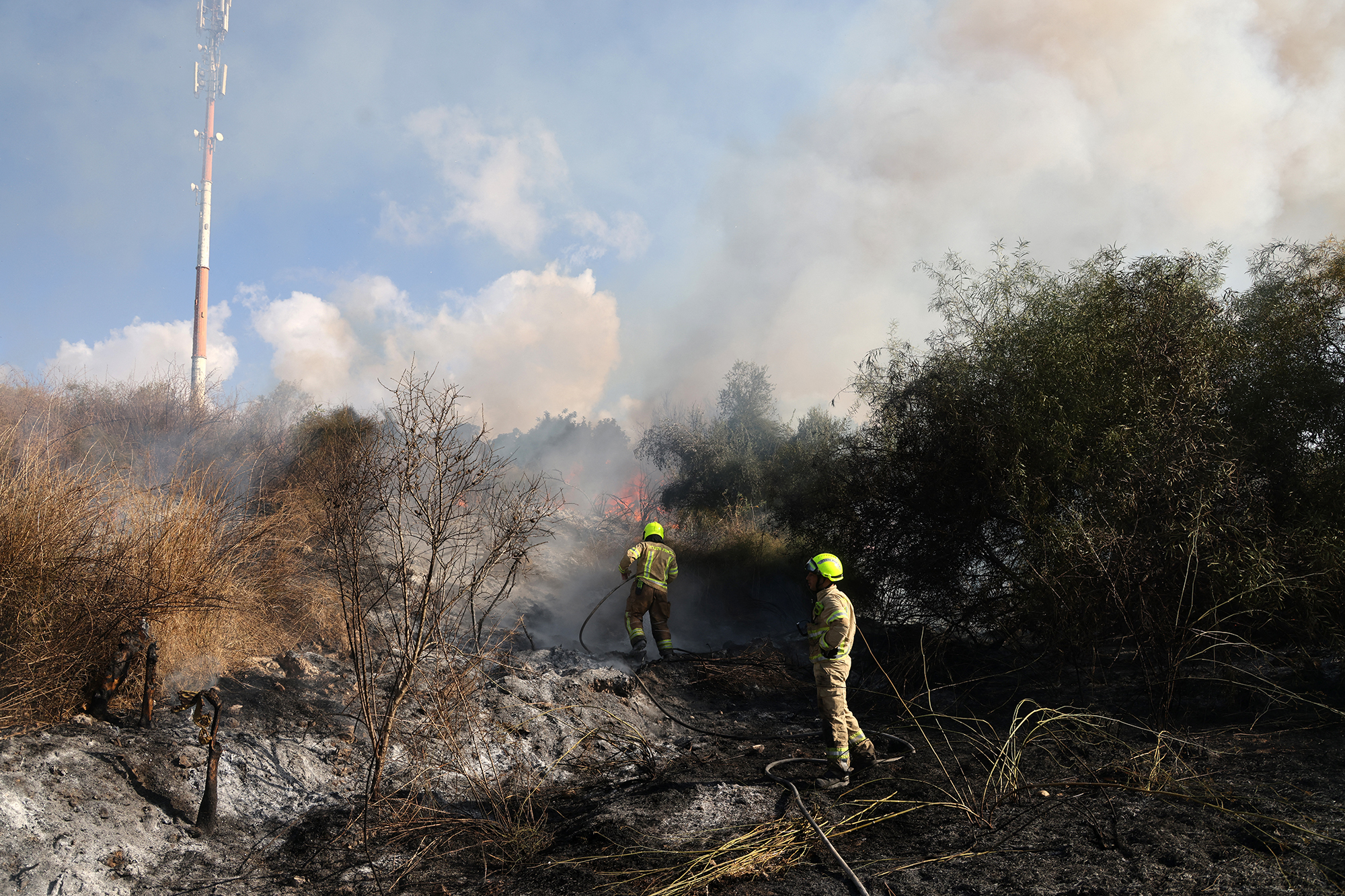 Feuerwehrleute löschen ein Feuer auf einer Freifläche in Lod in der Nähe von Tel Aviv, das Berichten zufolge durch eine aus dem Jemen abgefeuerte Rakete verursacht wurde