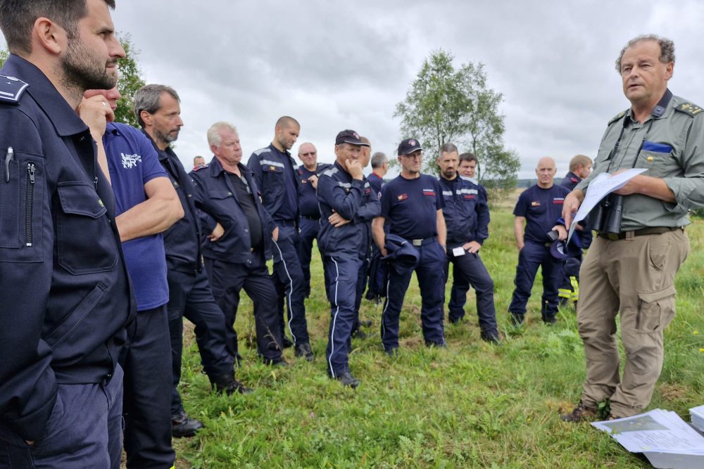 Mitarbeiter verschiedener Feuerwehren aus Belgien und Deutschland machen bei einer grenzüberschreitende n Katastrophenschutzübung eine Begehung des Lagers Elsenborn