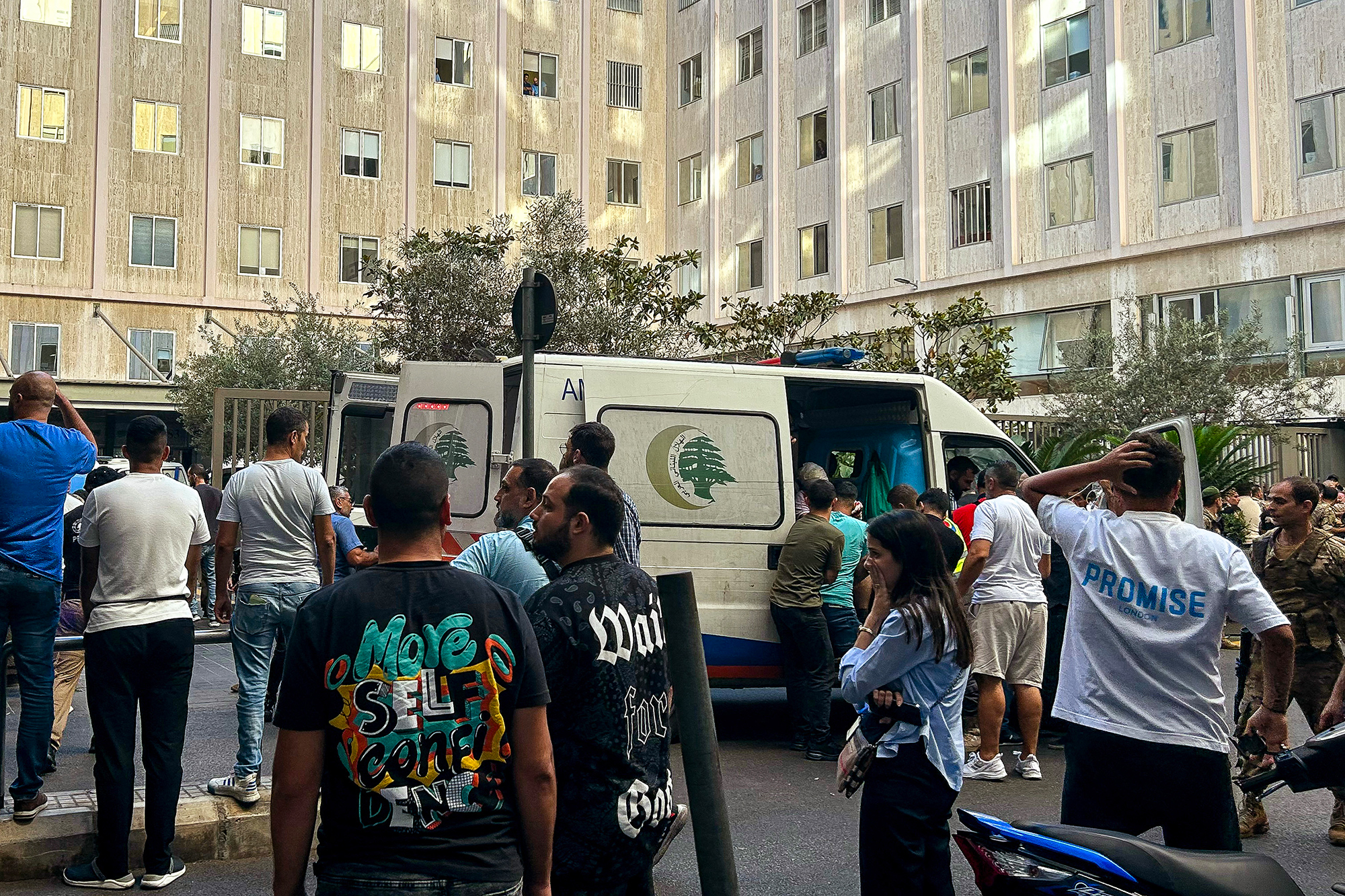 Menschen stehen in der Nähe eines Krankenwagens, der Verletzte in ein Krankenhaus in Beirut bringt