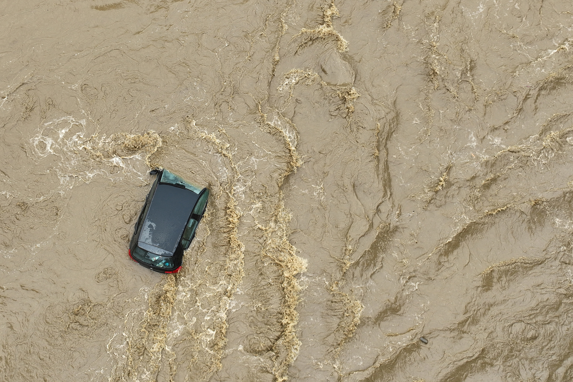 Dieses Luftbild zeigt ein Auto, das in einer überfluteten Straße in Glucholazy, Südpolen, im Wasser versunken ist