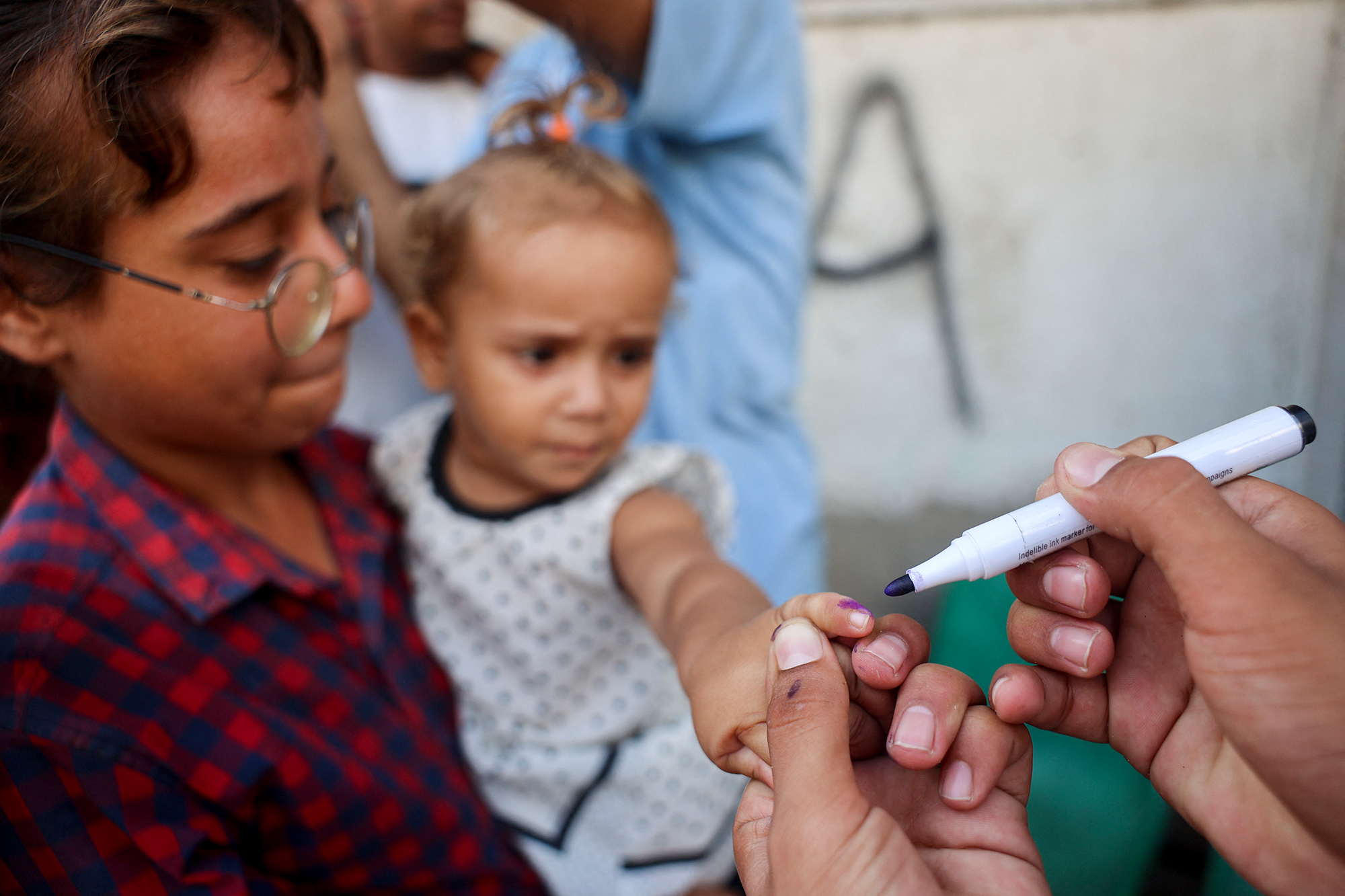 Ein gerade gegen Polio geimpftes kleines Mädchen wird mit einem Stift am Finger markiert, um zu zeigen, dass die die Impfung bereits erhalten hat