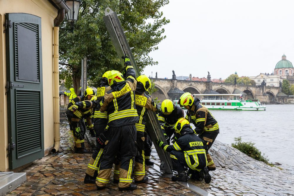 Feuerwehrleute an der Karlsbrücke in Prag bauen Flutschutzbarrieren