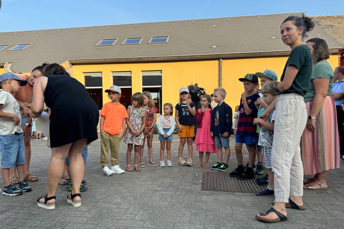 Eltern mit ihren Kindern auf dem Schulhof der Grundschule Walhorn