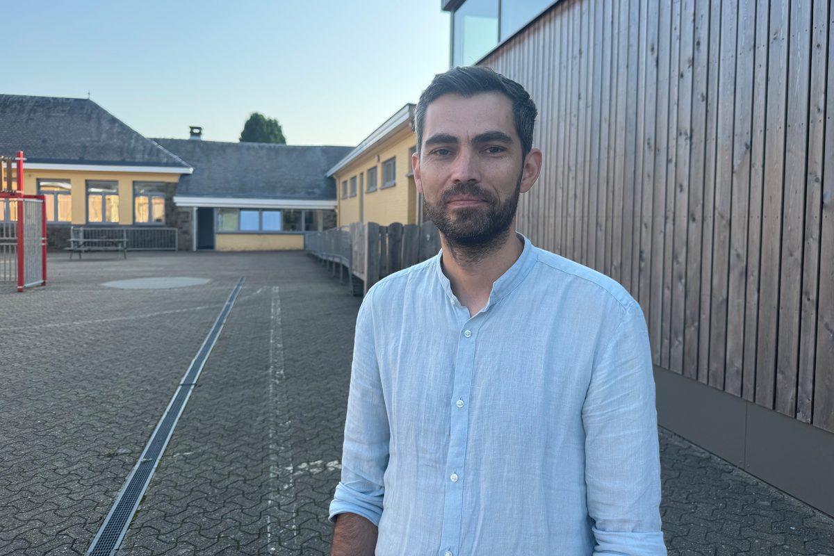 Der Leiter der Gemeindeschule Lontzen-Walhorn, Thomas Brüll, steht auf dem Schulhof und schaut in die Kamera