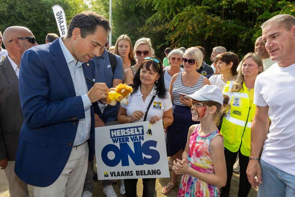 Der Vorsitzende des Vlaams Belang, Tom Van Grieken, während des jährlichen Familientags und des Starts der Kommunalwahlkampagne der flämischen rechtsextremen Partei Vlaams Belang in Planckendael - er gibt einem Mädchen ein Autogramm auf einem kleinen Kuscheltierlöwen