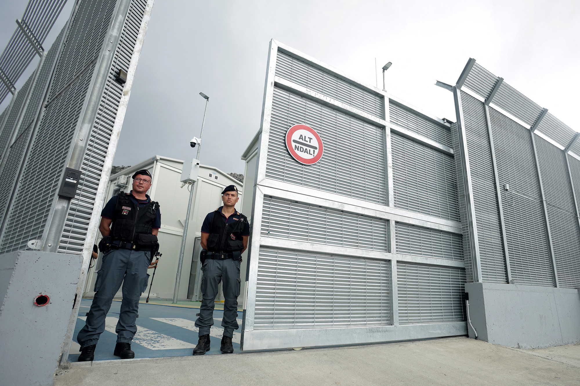 Italienische Polizisten stehen am Eingang eines von Italien betriebenen Migrantenzentrums im Hafen von Shengjin, etwa 60 Kilometer nordwestlich von Albaniens Hauptstadt Tirana