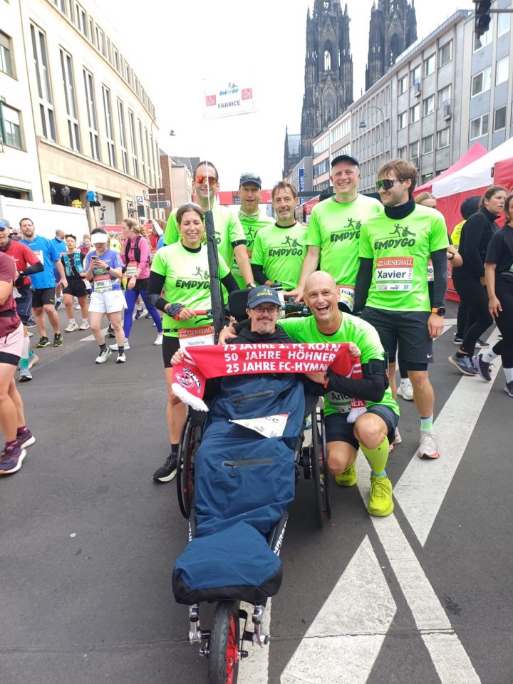 Fabrice Aldenhoff aus Kelmis sitzt im Emdygo-Rollstuhl, um ihn herum stehen die Läufer des Teams