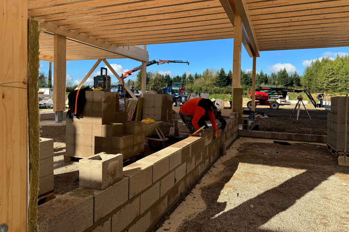 Arbeiter errichten eine Mauer aus Betonsteinen