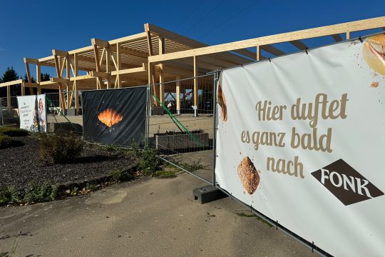 Vor der Baustelle sind Werbebanner der Bäckerei Fonk am Bauzaun angebracht