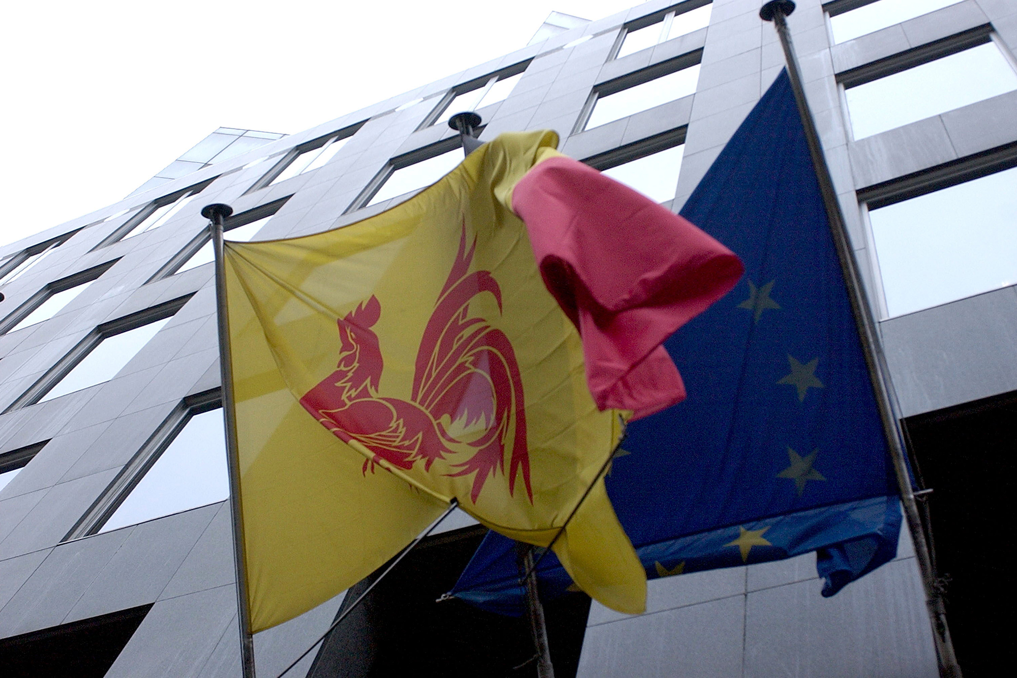 Drei Flaggen wehen vor dem Sitz der Französischen Gemeinschaft in Brüssel: die Flagge der FG, die belgische Nationalflagge sowie die Flagge der Europäischen Union