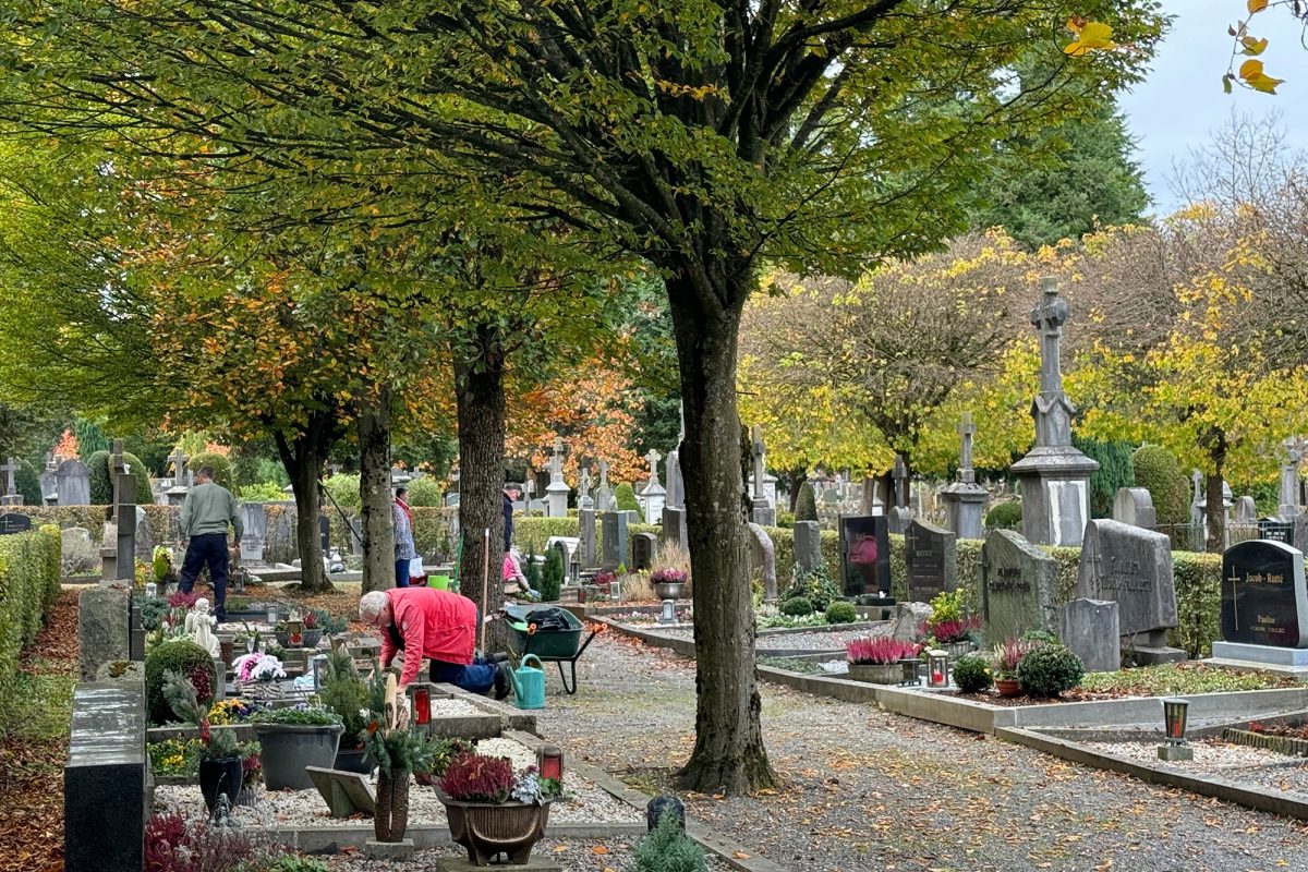 Menschen arbeiten an einem Grab auf dem Eupener Friedhof kurz vor Allerheiligen