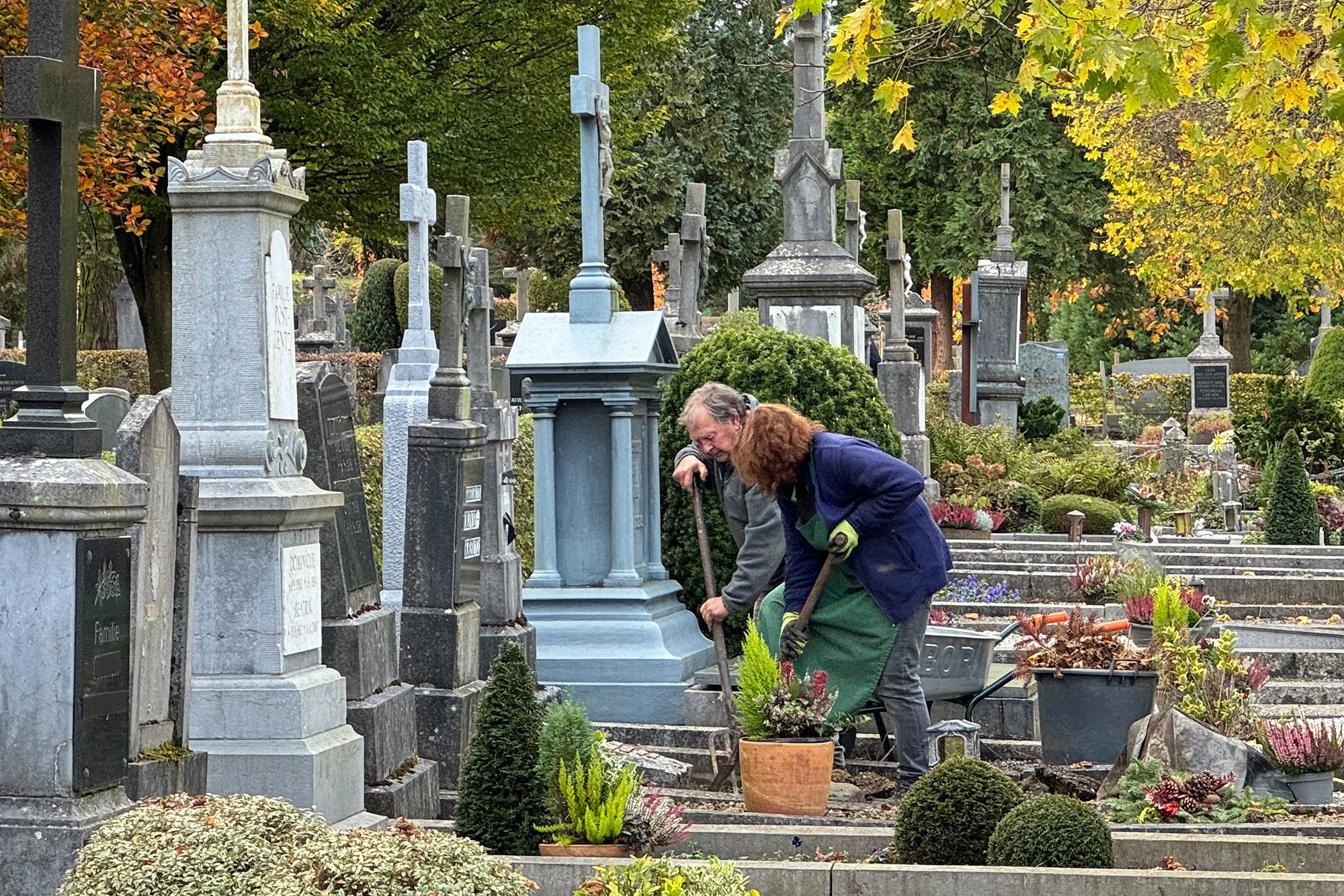 Menschen arbeiten an einem Grab auf dem Eupener Friedhof kurz vor Allerheiligen