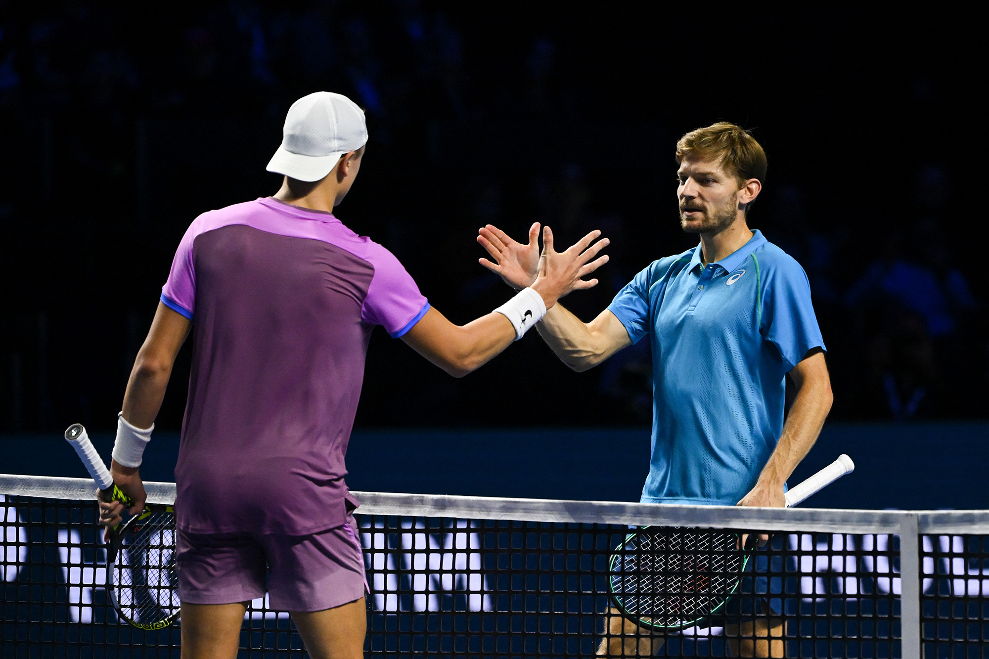 David Goffin und der Däne Holger Rune geben sich im Anschluss an das Spiel überm Tennisnetz die Hände