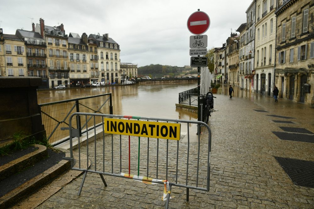 Auf einem Zaun ist ein Schild angebracht mit der Aufschrift „Hochwasser“, daneben ist der Fluss La Nive in Bayonne in Südwestfrankreich