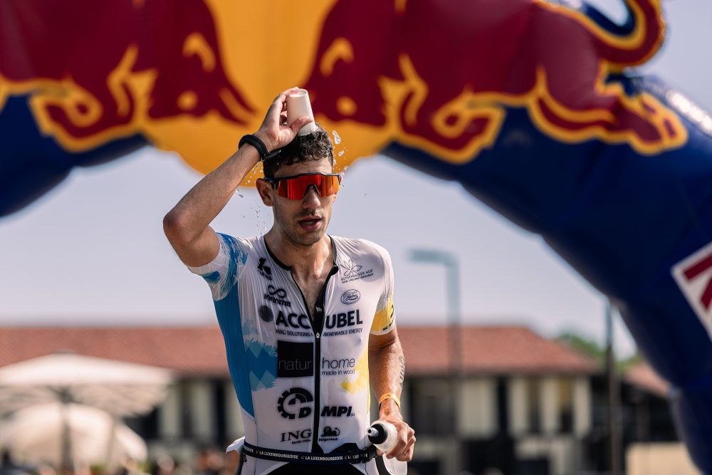 Triathlet Louis Heukemes schüttet sich beim Laufen Wasser über den Kopf