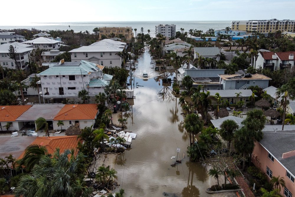 Auf diesem Luftbild fährt ein Fahrzeug durch eine überflutete Straße nach dem Hurrikan Milton in der Stadt Siesta Key in Florida