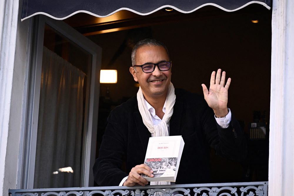 Kamel Daoud hält sein Buch "Houris" aus einem Fenster in Paris