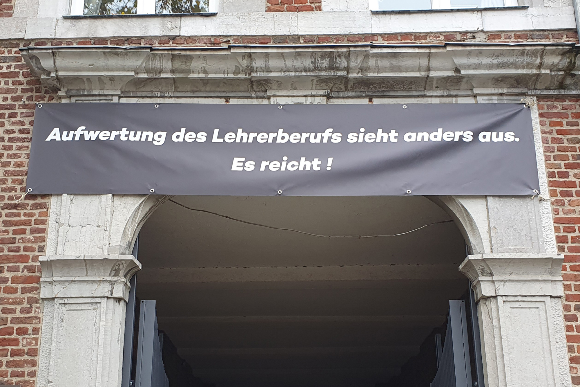 Banner über dem Torbogen der Eupener Pater-Damian-Sekundarschule