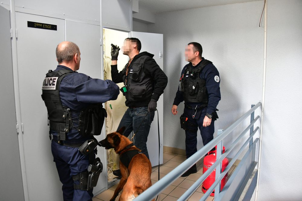 Französische Polizisten führen mithilfe eines Polizeihunds eine Razzia im Drogenmilieu durch