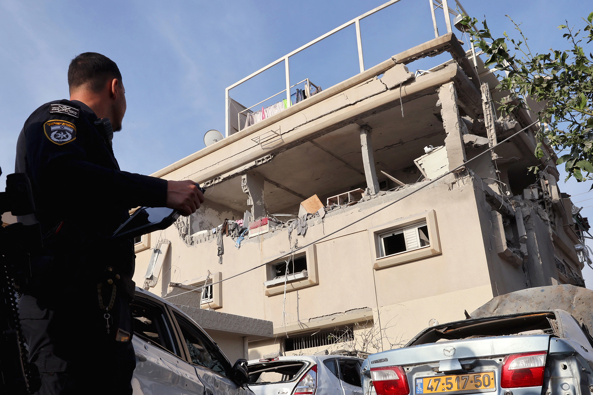 Ein israelischer Polizist schaut auf ein beschädigtes Gebäude nach einem Raketenangriff aus dem Südlibanon auf die zentralisraelisch-arabische Stadt Tira