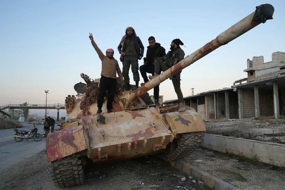 Islamistische Rebellen posieren auf einem Panzer auf der Straße nach Maaret al-Numan in der nordwestlichen Provinz Idlib in Syrien für ein Foto