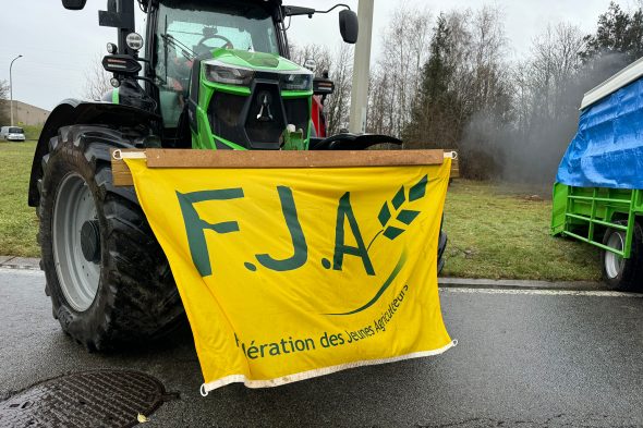 Traktor mit Fahne steht auf der Autobahn