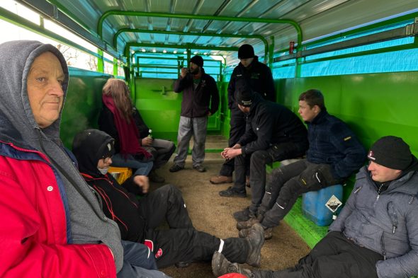 Protestierende Bauern sitzen in einem Viehwagen