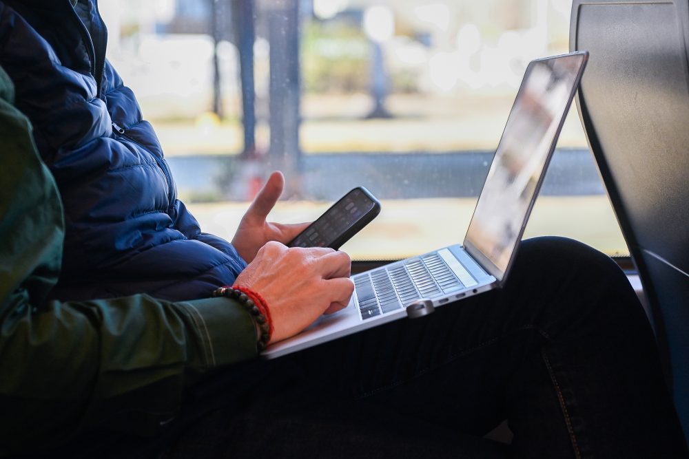 Fahrgast mit Laptop und Smartphone im Zug