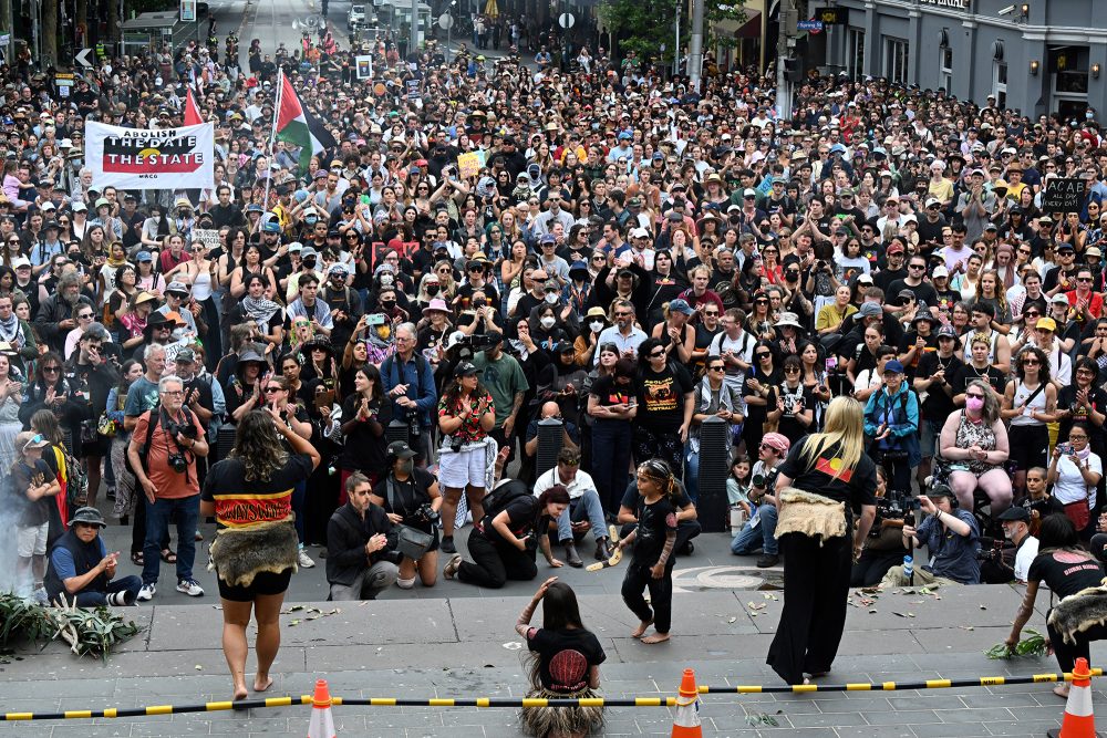 Demonstranten nehmen am jährlichen „Invasion Day“-Protestmarsch durch die Straßen von Melbourne teil, vorne im Bild tanzt eine Gruppe von Ureinwohnern