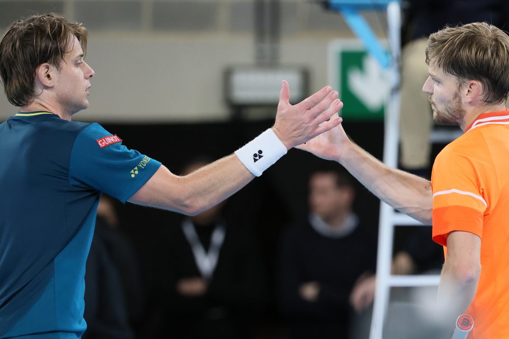 Zizou Bergs und David Goffin stehen gemeinsam auf einem Tennisfeld und schlagen ein