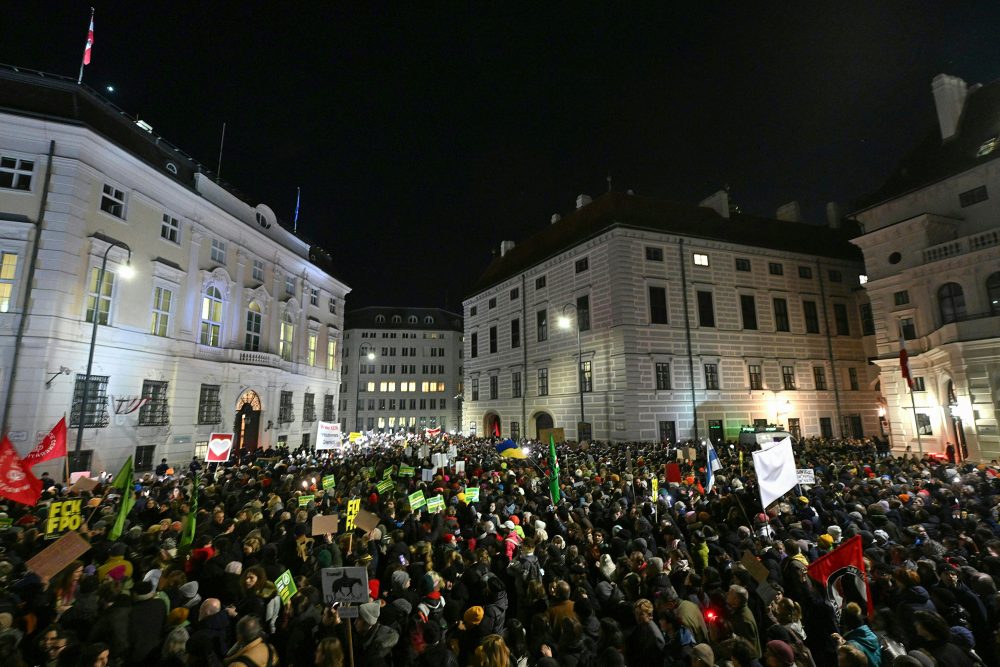 Tausende Menschen haben sich für eine Kundgebung zwischen dem Bundeskanzleramt und dem Präsidialamt am Ballhausplatz in Wien versammelt, viele halten Protestschilder in die Höhe